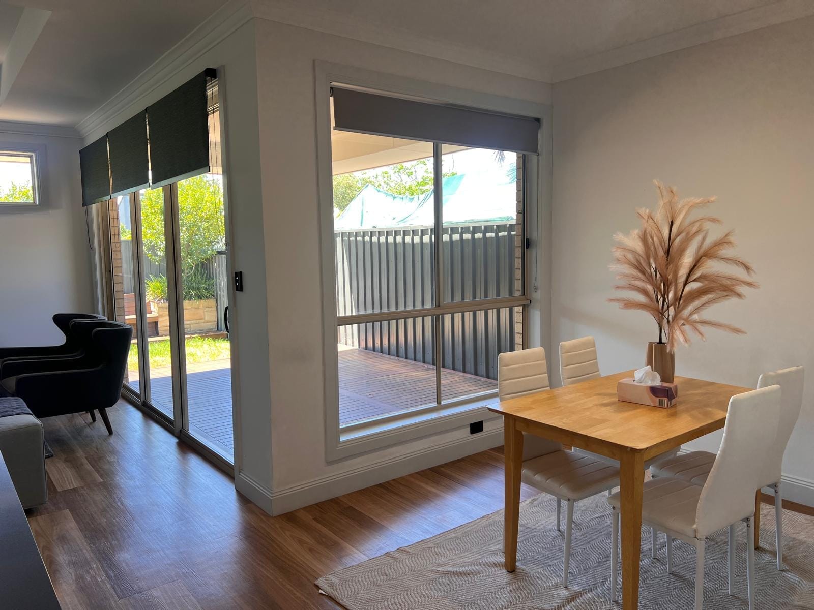 Dining nook with a wooden table beside large glass doors.
